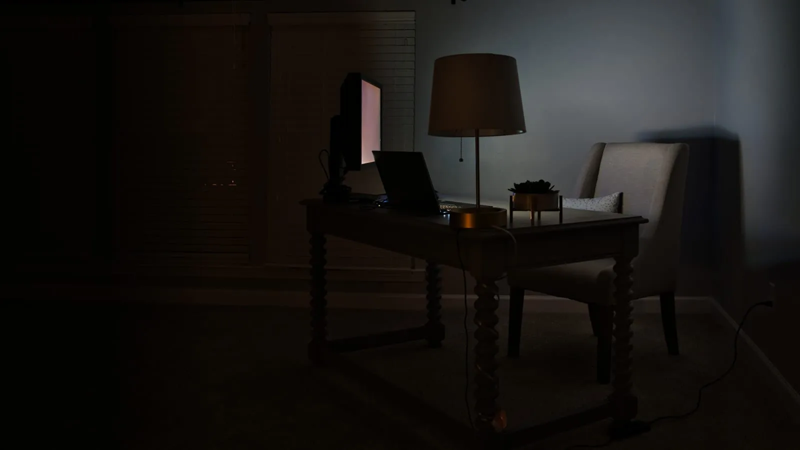 Laptop open to a financial spreadsheet glowing in a dark room at night